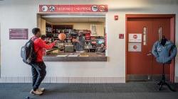 View of Equipment Checkout window with a student checking out a basketball